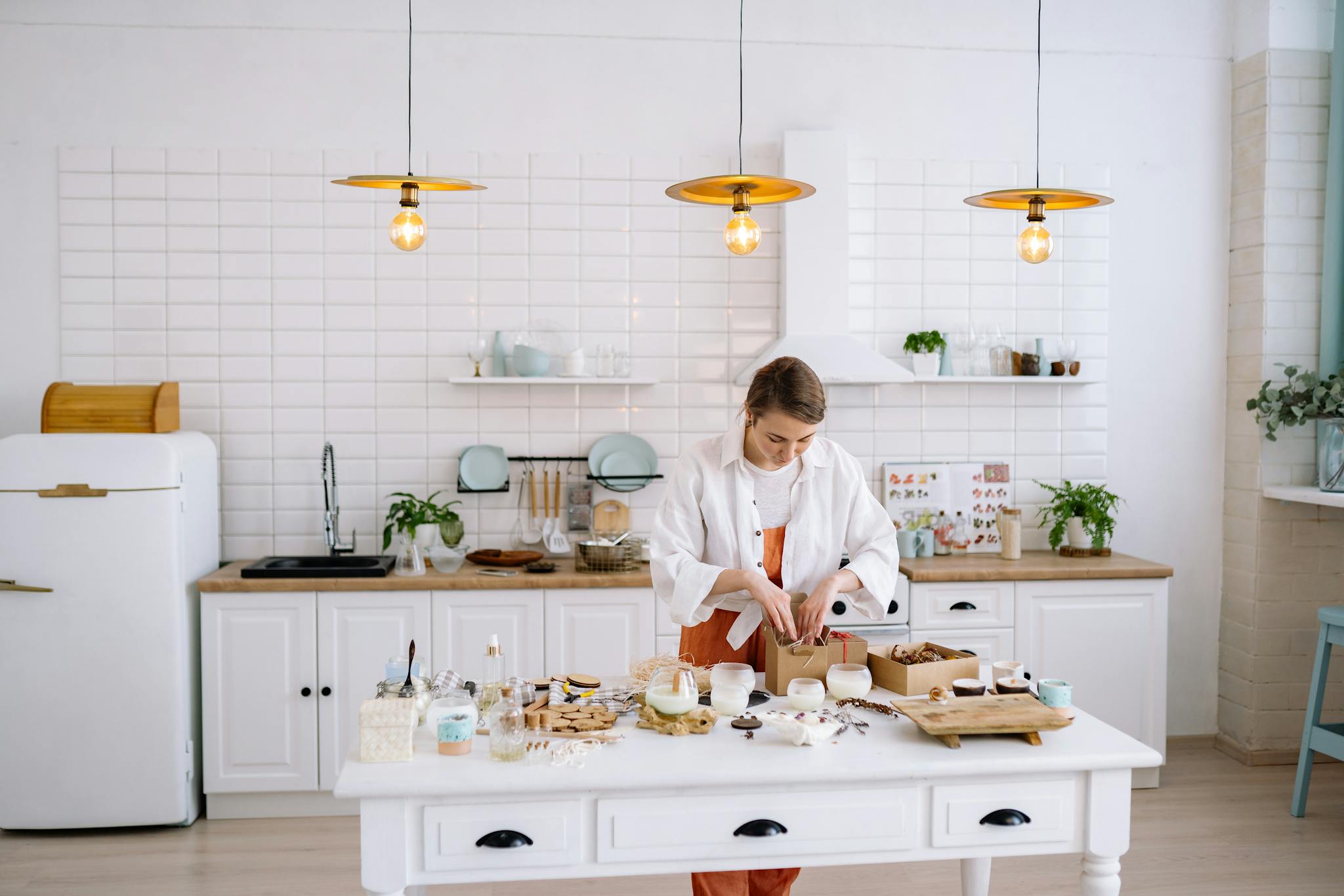 Woman creating handmade crafts in a cozy, modern kitchen setting with warm lighting.